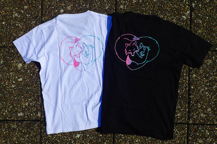 Tee-shirts (Tshirts) with a motif printed using silkscreen representing a tanuki and a kitsune cuddling.